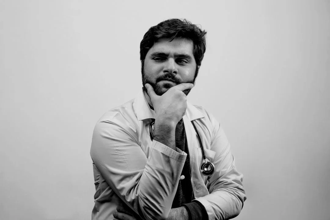 man in black jacket with his hand on his mouth